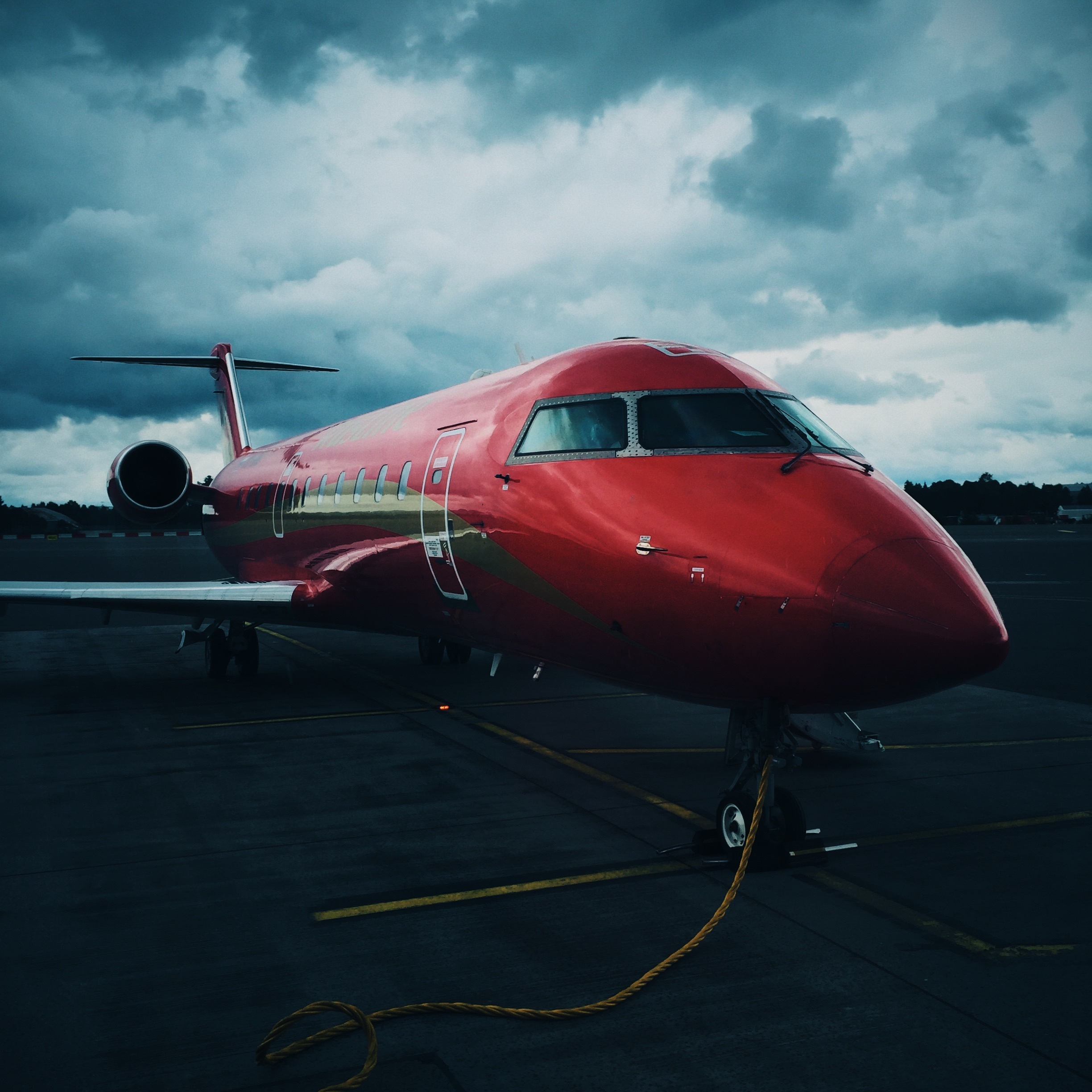 Rotes Flugzeug am bewölkten Flughafen