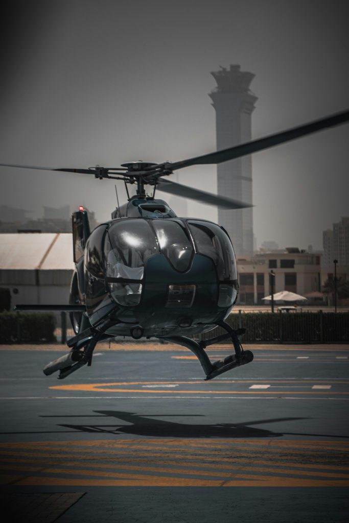 Hubschrauber landet auf einem Landeplatz vor Turm