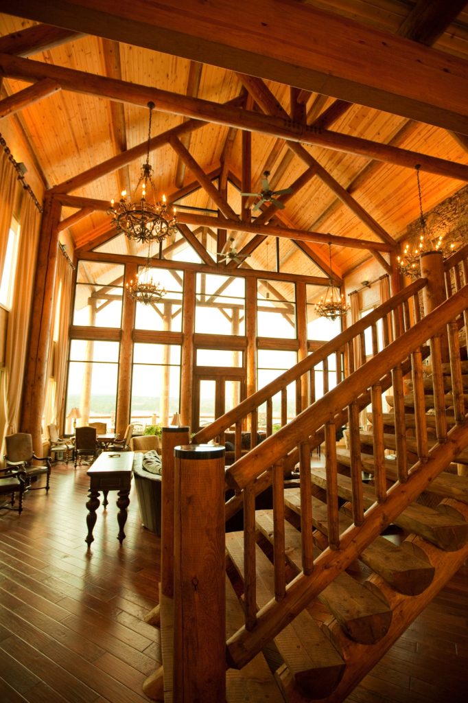 Rustikale Holzhütte mit Balkendecke und Treppe.